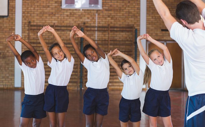 Photo of children in gym class doing side stretches
