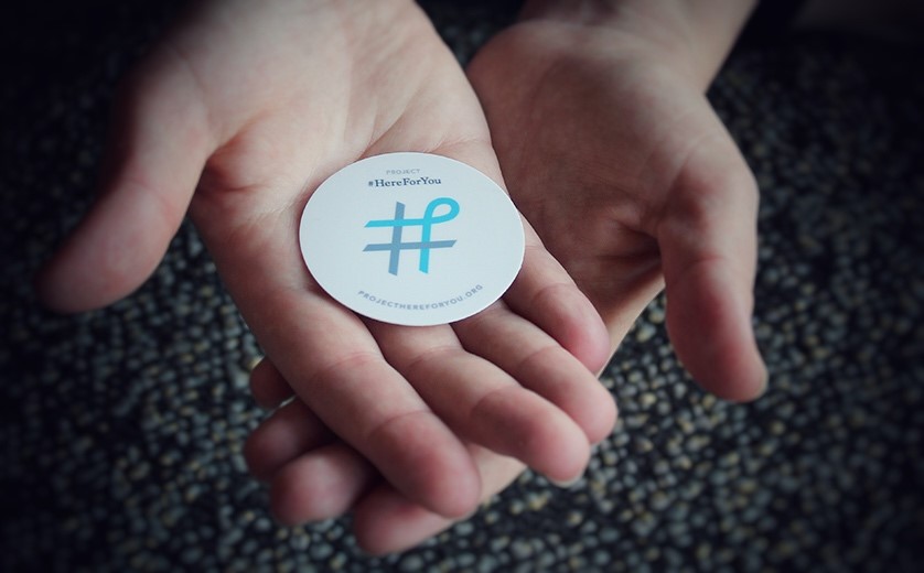 Miriam Joelson holds a Project #HereForYou sticker