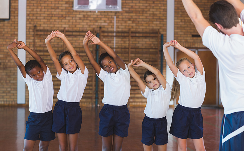 Photo of children in gym class doing side stretches