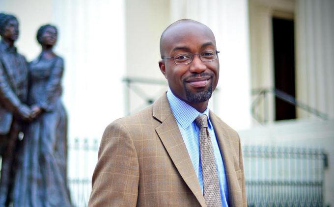 Image of Dr. Jason Purnell standing in front of a statue.