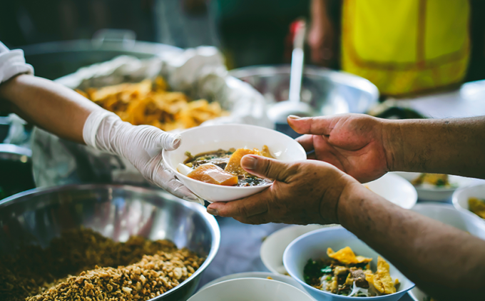 A person receives food from an aid worker.